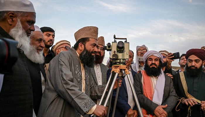 Central Ruet-e-Hilal Committee Chairman Maulana Abdul Khabeer Azad, surrounded by religious scholars and clerics, looks in the telescope to spot the crescent moon in this undated image. — AFP/File