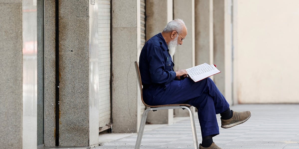 A security guard recites the Holy Quran at the premises of a shopping mall in Karachi on March 2, 2025. — Reuters