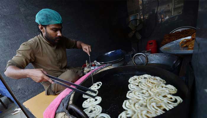 Vendor busy frying traditional food item (Jalabi) on first day of Ramadan, March 2, 2025. — INP