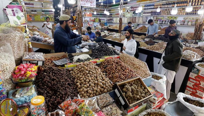 People buy dried fruits at a market in Karachi, February 1, 2023. — Reuters