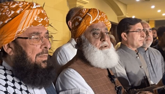 Maulana Fazlur Rehman addresses a post-midnight press conference along with PTI Chairman Gohar Khan and leader Asad Qaiser on October 18, 2024. — Screengrab/Facebook@juipakofficial