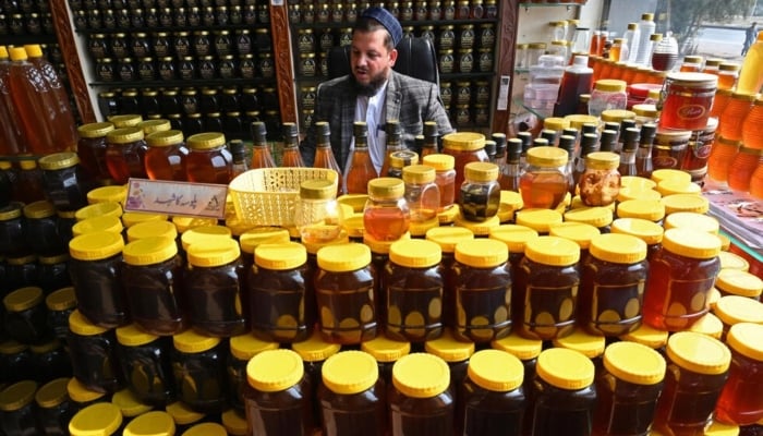 A honey vendor waits for customers market in Chamkanni on the outskirts of Peshawar. — AFP/File