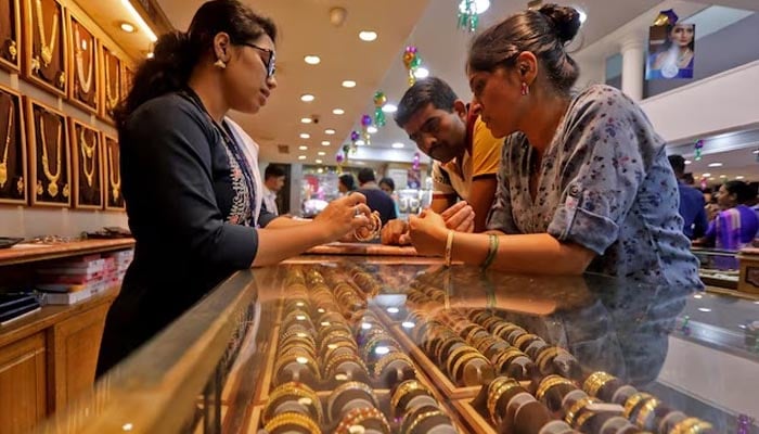 People shop for gold ornaments at a jewellery showroom during Dhanteras, a Hindu festival associated with Lakshmi, the goddess of wealth, in Mumbai, India, October 22, 2022. — Reuters