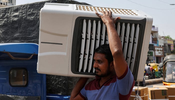 A worker carries an air cooler for delivery to a customer during the heat wave in Ahmedabad, India, May 30, 2024. — Reuters