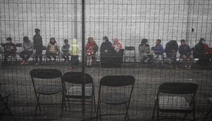 Afghan refugees queue outside a distribution and donation center at Liberty Village on Joint Base McGuire-Dix-Lakehurst in New Jersey, US, December 2, 2021. — Reuters