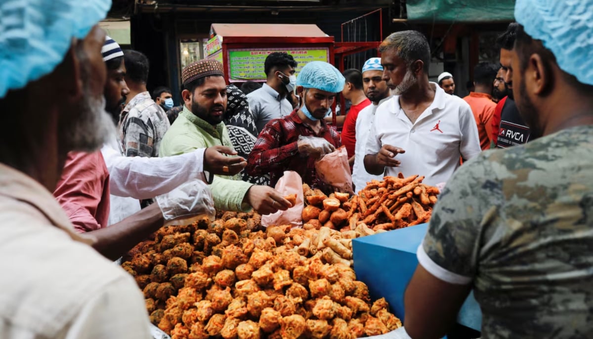 People purchase food for iftar meal from the Chawkbazar makeshift market during the first day of the holy month of Ramadan in Dhaka, Bangladesh. — Reuters