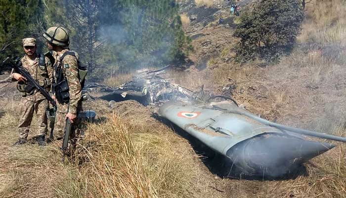 Pakistan Army soldiers stand next to the wreckage of an Indian fighter jet shot down by the Pakistan Air Force in the Bhimber district in Azad Jammu and Kashmir on February 27, 2019. — AFP