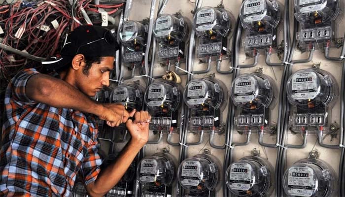 A technician from Karachi Electric, Pakistan’s largest city’s power supply company, fixes new electricity meters at a residential building. — AFP/File