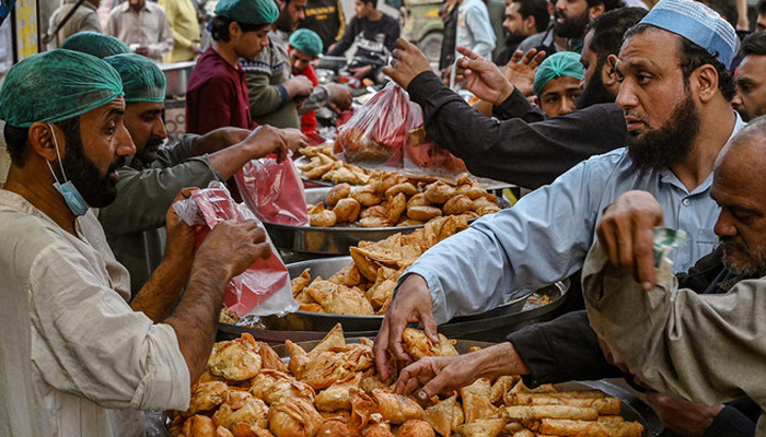 Muslim devotees buy Iftar food before breaking their fast on the first day of the Islamic holy month of Ramadan, at a market in Lahore on March 12, 2024. — AFP