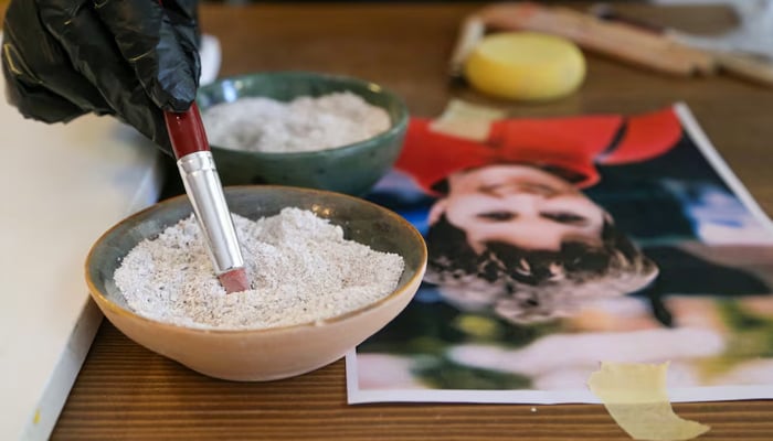 Serap Lokmaci, a painter who works with sand for her drawings, makes a portrait of Hungarian woman Katalin Kollar using ashes from her cremation, in Urgup, central Nevsehir province, Turkey, February 27, 2025. — Reuters