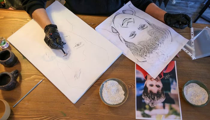 Serap Lokmaci, a painter who works with sand for her drawings, makes a portrait of Hungarian woman Katalin Kollar using ashes from her cremation, in Urgup, central Nevsehir province, Turkey, February 27, 2025. — Reuters