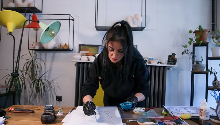 Turkish artist Serap Lokmaci works on a portrait of Hungarian woman Katalin Kollar using ashes from her cremation, in Urgup, central Nevsehir province, Turkey, February 27, 2025. — Reuters