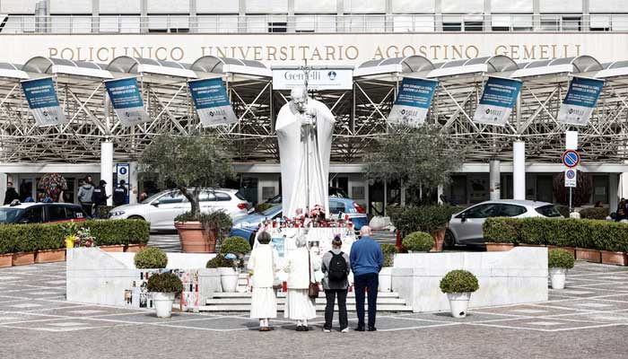 People gather in front of the statue of late Pope John Paul II outside Gemelli Hospital, where Pope Francis is admitted for treatment, in Rome, Italy, March 8, 2025. — Reuters