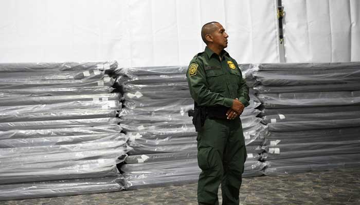 A US Border Patrol agent stands in front of sleeping mats. — Reuters/File