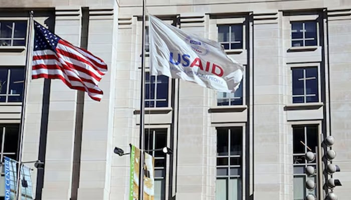 An American flag and USAID flag fly outside the USAID building in Washington, DS, US, February 1, 2025. — Reuters