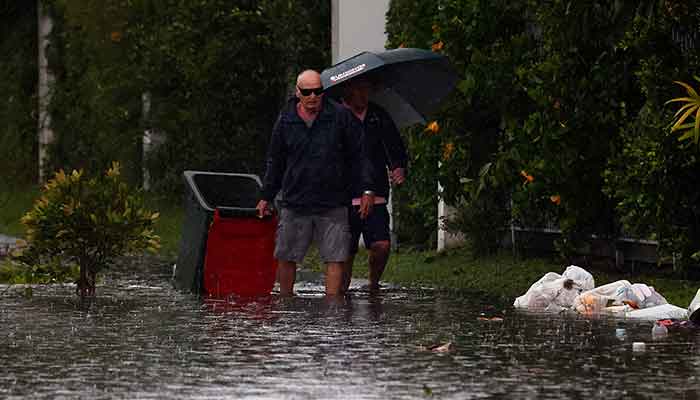 People wade through a flooded street after storm Alfred in Cabarita Beach, Northern New South Wales, March 10, 2025. — Reuters