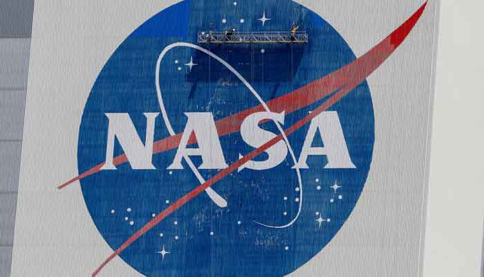 Workers pressure-wash the logo of Nasa on the Vehicle Assembly Building before SpaceX will send two Nasa astronauts to the International Space Station aboard its Falcon 9 rocket, at the Kennedy Space Centre in Cape Canaveral, Florida, US, May 19, 2020. — Reuters