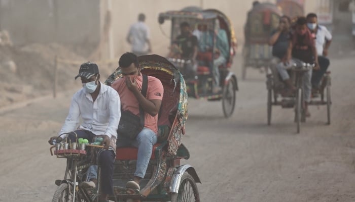 People move through a dusty road, as air quality reduces ahead of the winter in Dhaka, Bangladesh, November 4, 2024. — Reuters