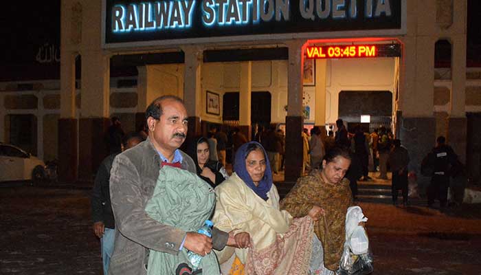 Passengers who were saved from a train after being attacked by activists, walk with their personal effects at Quetta station, Balutchistan, March 12, 2025. - Reuters 