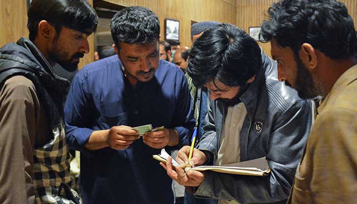 Passengers who were saved from a train after being attacked by activists, register at Quetta station, Balutchistan, March 12, 2025. - Reuters 