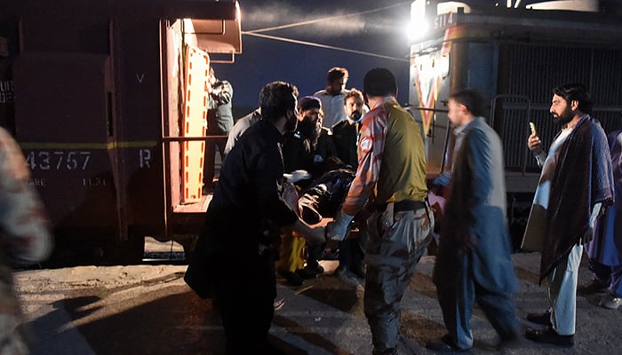 Bystanders help to evacuate an injured passenger on a stretcher at the Mach railway station, which has been turned into a makeshift hospital in Mach, Balochistan on March 11, 2025. — AFP