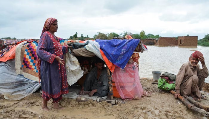 A family takes refuge on a higher ground following rains and floods during the monsoon season in Dera Allah Yar, district Jafferabad, Balochistan, on August 25, 2022. — Reuters