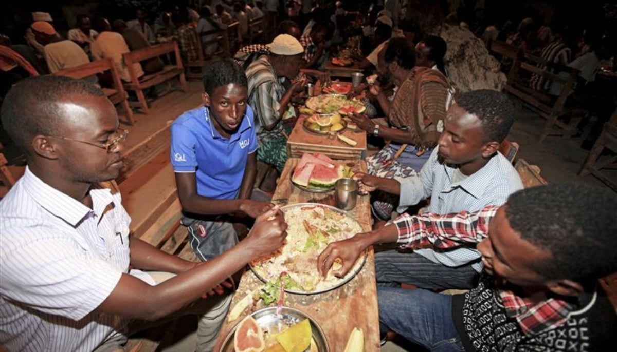 Somali Muslim men eat during iftar, as they break their fast, at the African Muslim agency during the holy month of Ramadan in Somalias capital Mogadishu. — Reuters