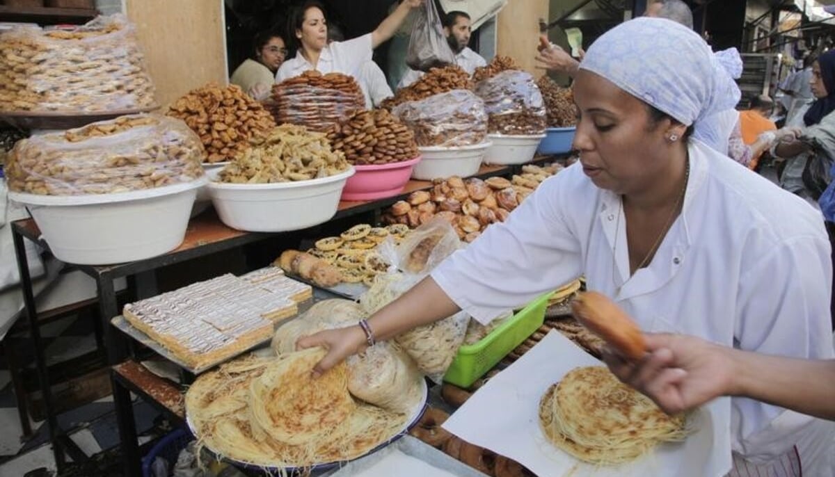 A vendor sells traditional cakes of fried honey and flour pastries to customers ahead of Ramadan in the medina of the Moroccan city of Rabat. — Reuters/File