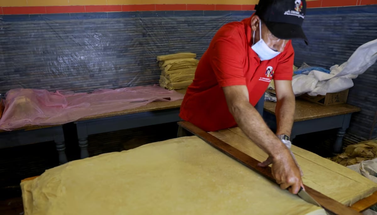 A worker cuts the dough of pastry sheets of sambusa snacks during the holy month of Ramadan in Sanaa, Yemen April 16, 2021. — Reuters