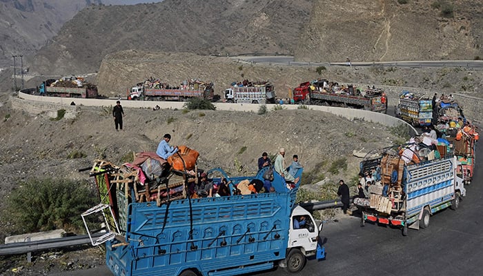 Trucks transporting Afghan refugees with their belongings are seen along a road towards the Pakistan-Afghanistan Torkham border on November 3, 2023. — AFP