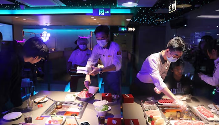 Waiters serve customers at a Haidilao hotpot restaurant in Beijing, China October 11, 2021. — Reuters