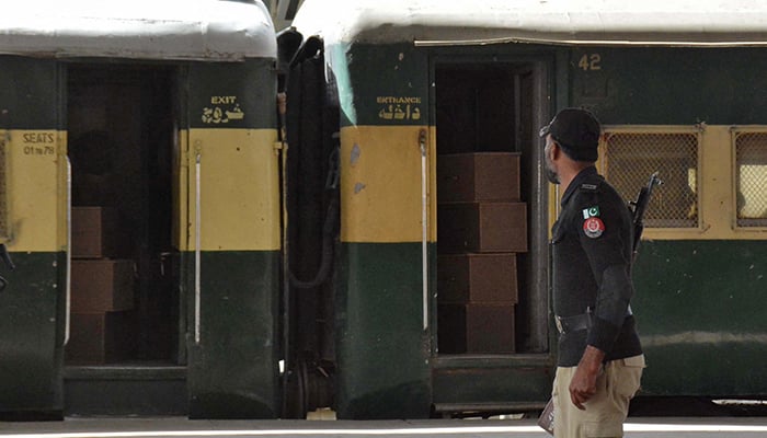 A security force personnel member stands guard near a train containing empty coffins that are dispatched to Bolan where a passenger train that was attacked by separatist militants, at a railway station in Quetta, March 12, 2025. — Reuters