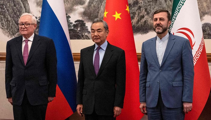 Chinas Foreign Minister Wang Yi (C) welcomes Russias Deputy Foreign Minister Sergey Ryabkov (left) and Irans Deputy Foreign Minister Kazeem Gharibabadi before a meeting regarding the Iranian nuclear issue at the Diaoyutai State Guesthouse in Beijing on March 14, 2025. — AFP