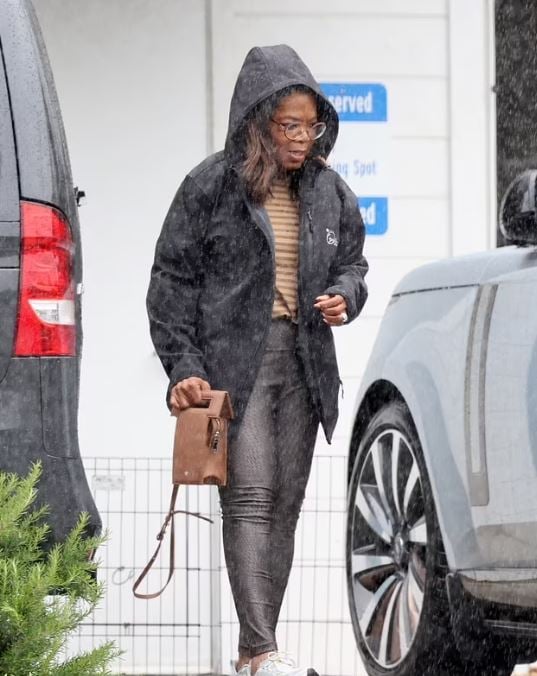 Oprah Winfrey toughs out rainfall with slim physique