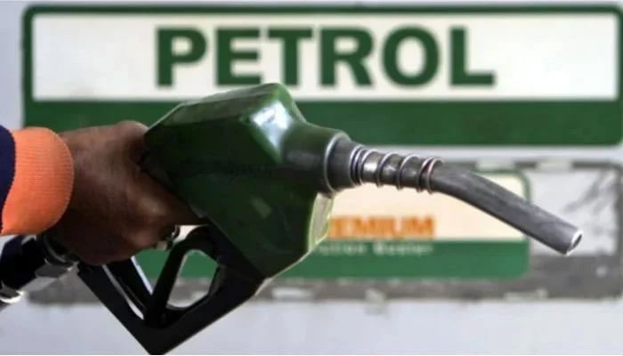 A fuel station worker holds a petrol nozzle at a petrol pump. — Reuters