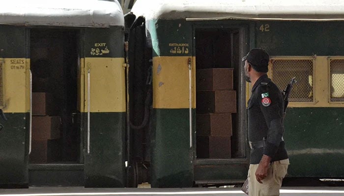 A member of the personnel of the security force is held near a train containing empty coffins which are sent to Bolan where a train of travelers who was attacked by separatist activists, in a station in Quetta, on March 12, 2025. - Reuters