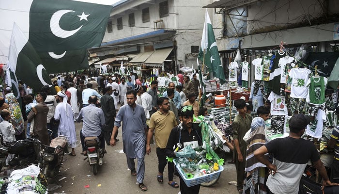 People walk through a market featuring roadside vendors in Karachi. — AFP/File