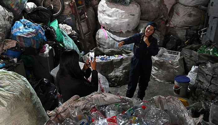 Creator of content for social networks, Sara Samaniego, known as Marce, the recycler, records a video at a recycling warehouse in Bogota on February 26, 2025. — AFP