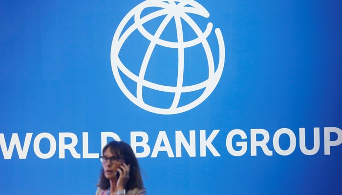 A participant stands near a World Bank logo in the International Monetary Fund - 2018 World Bank Annual Meeting in Nusa Dua, Bali, Indonesia, October 12, 2018. - Reuters