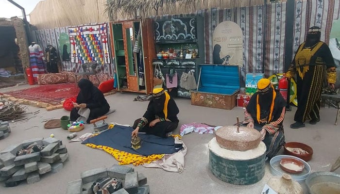 Women dressed in traditional clothes perform ancient household practices in Taif, Saudi Arabia. — Reporter