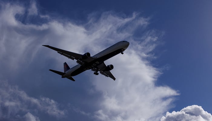 An airplane descends in front of the stormy clouds when approaching the earth on December 12, 2022. - Reuters