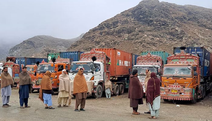 People stand next to parked trucks loaded with supplies at the Torkham border crossing following the closure of the border crossing between Pakistan and Afghanistan, March 3, 2025. — Reuters