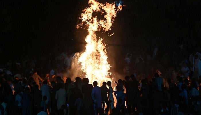 People gather around a bonfire as they celebrate Holi in Mithi on March 13, 2025. — AFP