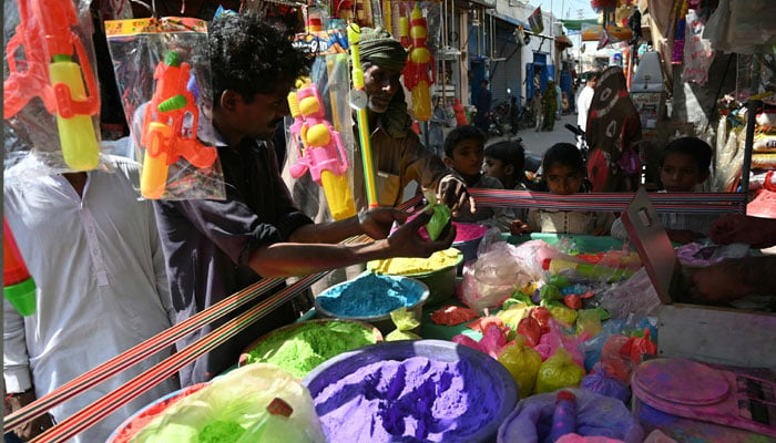 Hindu residents buy colour powders to celebrate Holi in Mithi on March 13, 2025. — AFP