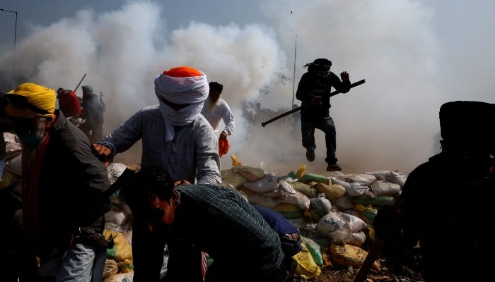 Farmers run for cover as police fire tear gas during a protest, at Shambhu barrier, a border crossing between Punjab and Haryana states, India, February 21, 2024. — Reuters