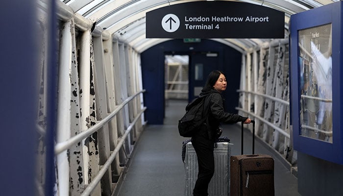 A passenger with luggage walks in a passage leading to Terminal 4 of Heathrow International Airport, after a fire at an electrical substation wiped out power at the airport, in London, Britain, March 21, 2025. — Reuters