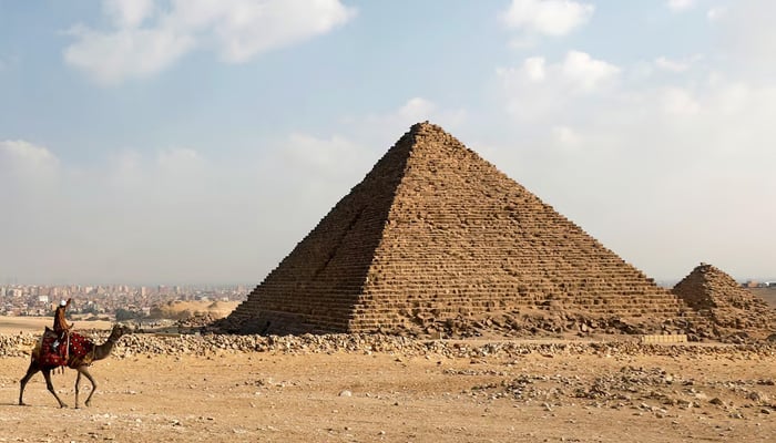 A camel guide waits for customers next to the pyramid of Khafre or Chefren at the Giza pyramids plateau in Giza, Egypt, December 18, 2020. — Reuters