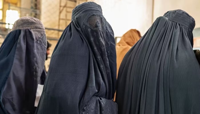 Afghan women wait to receive food aid from a nongovernmental organisation in Kabul on January 17, 2023. — AFP