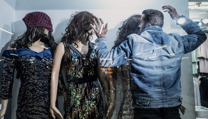 An Afghan shopkeeper adjusting womens wigs placed on mannequins at his shop in Kabul on March 13, 2025. — AFP