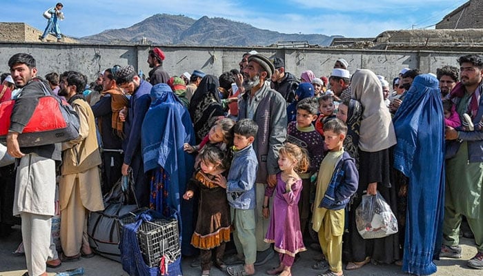 Afghan refugees wait in a queue to cross the Pakistan-Afghanistan border in Torkham on October 27, 2023. — AFP